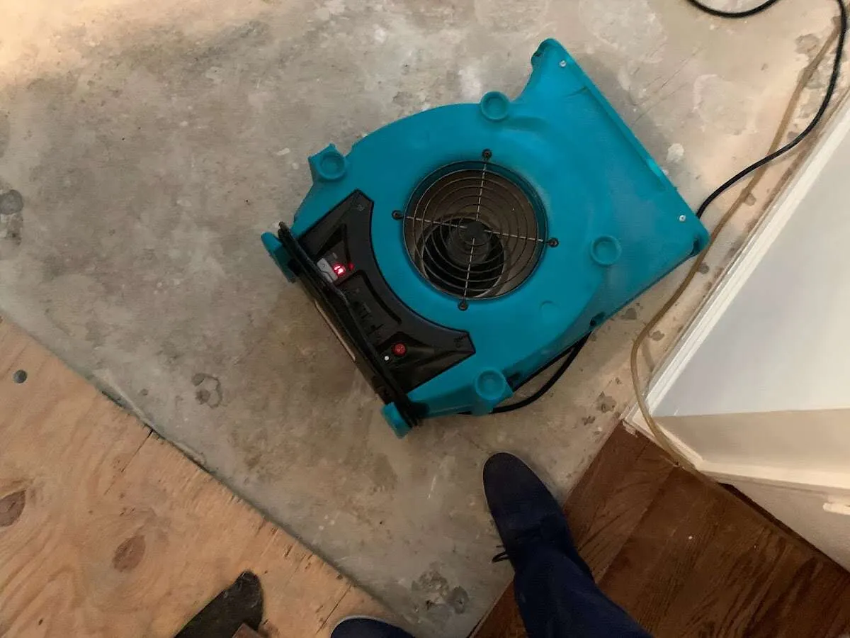 Air mover drying subfloor during Commercial Water Damage Restoration in Woods Cross